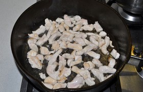 В сковороду с раскаленным маслом закладываем полоски куриного филе, перемешивая, обжариваем 3-4 минуты – до того момента, как филе станет светлым и начнет браться корочками.