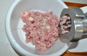 Мясо с куриных окорочков (оно сочнее, чем грудка) прокручиваем разок через крупную решетку мясорубки.