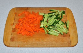 Огурец – тонкими брусочками. Так же, на терке или с помощью ножа, нарезаем морковь. Укладываем в миску. 