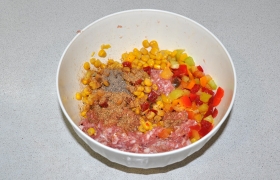 В миску с фаршем добавляем кукурузу, нарезанный небольшим кубиком сладкий перец. Посыпаем солью и перцем, можем использовать и готовую приправу для мяса-фарша.