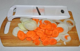 Чистим и тонко нарезаем лук и чеснок. Мы можем делать это ножом, но лучше быстро и тонко нарезать овощи на терке для капусты.