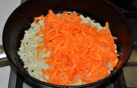 Добавляем к луку тертую или нарезанную морковь, продолжаем пассеровать еще 4-5 минут.