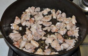 На сильном огне раскаляем масло в толстодонной сковороде. Закладываем куриное мясо и 2-3 минуты быстро обжариваем кусочки до легких корочек, все время переворачивая и перемешивая лопаткой. В конце – солим и перчим.