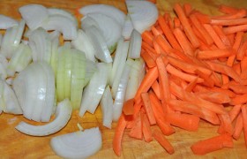 Чистим и нарезаем длинной, довольно крупной соломкой морковь. Очищенный лук делим на четвертинки и шинкуем.