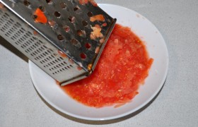 Помидоры измельчаем, скорее и легче всего это делается так: делим помидоры пополам, половинки натираем на терке. Выливаем массу в латку.