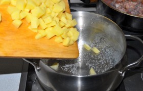 Тем временем вода в кастрюле, которую мы между делом поставили на огонь, кипит, и мы загружаем в нее нарезанный картофель.