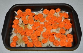 Очищенные овощи нарезаем: луковицы – кольцами или половинками, морковь – кружками. Смазываем противень (форму) маслом, раскладываем лук, сверху – морковь. Посыпаем солью, перцем – или приправой для курицы.