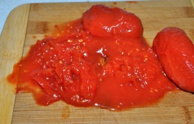 Консервированные помидоры разминаем вилкой или мелко рубим ножом на доске. Свежие томаты, предварительно искупав в кипятке и затем в ледяной воде, избавляем от кожицы, измельчаем.