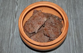 Тушить мясо удобнее в одном большом глиняном горшке, если нет - подойдет и латка, толстостенная кастрюля. В любом варианте на дно кладем сливочное масло, выкладываем мясо, 