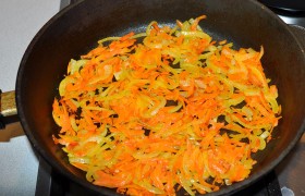 Пока разогревается на среднем огне сковорода с маслом, быстро шинкуем луковицу тонкими половинками или четвертинками колец, а морковь натираем. 10-12 минут  пассеруем , периодически перемешивая, и выкладываем в тарелку для остывания. Солим, перчим. 