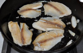 Тесто и рыбу размораживаем. Пока подходит тесто, готовим начинку. Промытые и обсушенные филе тилапии быстро обжариваем на масле, на средне-сильном огне, примерно 2-3 минуты сторону.