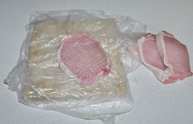 Вот так, в пакете,  отбиваем  мясо до толщины чуть меньше 1 см. Ровными несильными ударами кухонного молотка по всей поверхности. Если слой сала стягивает мясо – надрезаем его в 1-2 местах. 