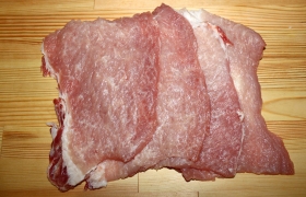 Накрывая пленкой или закладывая в пакетик, легонько отбиваем обе стороны пластов мяса. Посыпаем по вкусу свежемолотым перцем.