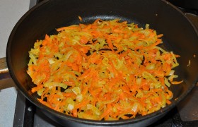 Вторая сковорода нам нужна для  зажарки . Для нее мы рубим луковицу и натираем морковку. Выкладываем на хорошо разогретую сковороду со смесью растительного и сливочного масел, хотя можем использовать и тот слой жира, что есть в тушенке.  Пассеруем  овощи 10 минут, огонь – средний. 
