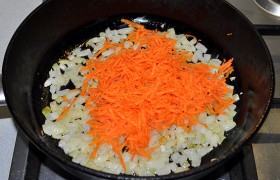 Шинкуем кубиком луковицу и опускаем в масло, разогретое на среднем огне. Помешивая,  пассеруем  лук 5-7 минут, до мягкости. Добавляем тертую морковь и обжариваем еще 3 минуты.