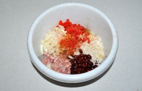 Соединяем в одной миске фасоль, рис, фарш. Мелко рубим томаты, лук, чеснок, посыпаем чили, кориандром, кумином, солью, перемешиваем и добавляем в миску. И вымешиваем начинку, пока она станет однородной.